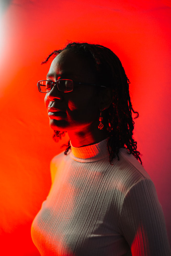 Autorin Sharon Dodua Otoo vor einem roten Hintergrund. 