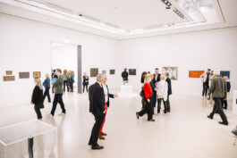 Besucher laufen durch die Ausstellung und unterhalten sich.