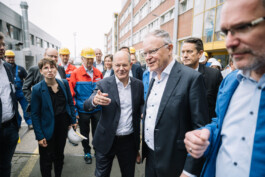 Olaf Scholz und Stephan Weil sprechen umringt von Personen der Meyer Werft.