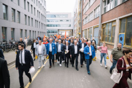 Olaf Scholz, Stephan Weil und Olaf Lies laufen vor einer Gruppe über das Gelände der Meyer Werft.