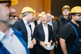 Olaf Scholz spricht in einer Gruppe von Menschen.