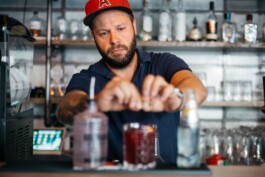 Ein Mitarbeiter bereitet Drinks an der Bar zu.