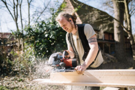 Ein Mitarbeiter des Betriebs Specht & Schwalbe arbeitet an einem Holzbalken 