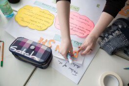 Eine Person klebt etwas auf ein Flipchart.