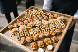 Bei dem Examenskonzert der E+S Rück trägt eine Person Schnittchen auf einem Tablett.