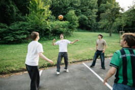 Toni und Ali spielen mit Gästen Fußball im Garten der Marburg WG.