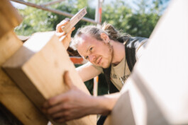 Ein Mitarbeiter des Betriebs Specht & Schwalbe arbeitet an einem Holzbalken